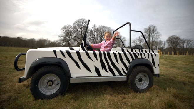 Girl sat in mini car at the Little Ranger Rovers new attraction at Woburn Safari Park